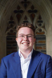Photo of J Shoemaker in front of Duke chapel hallway